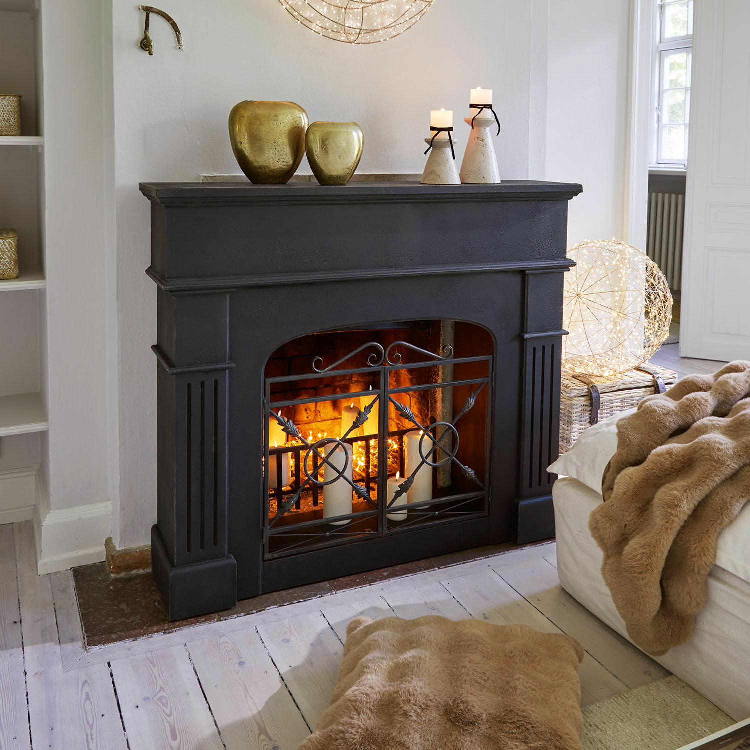 Consola de chimenea Hollowfield Chimenea negra con rejilla metálica y velas, decorada con jarrones dorados, salón acogedor con manta de piel sintética