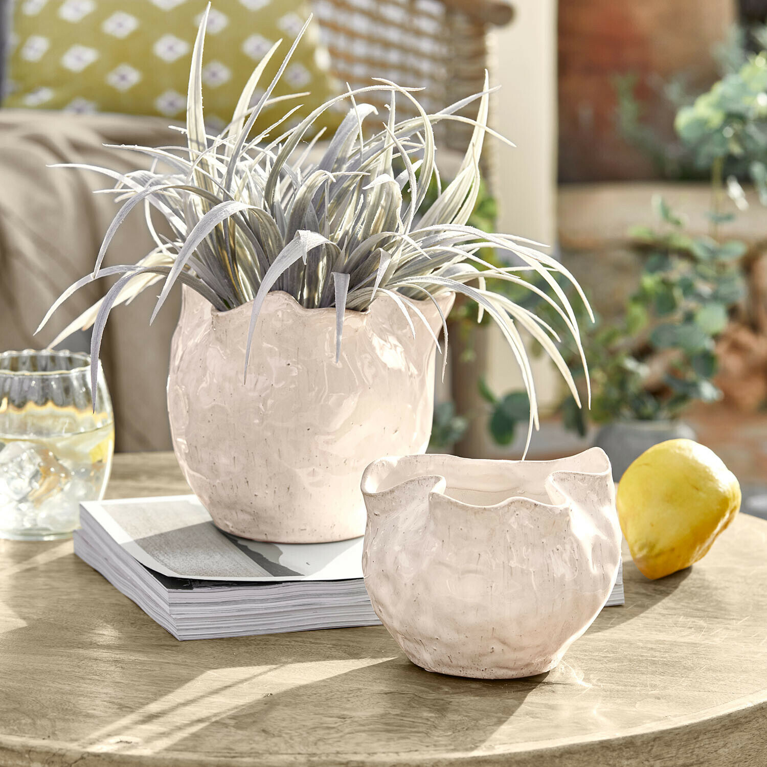 Set de 2 maceteros. Vérolines Macetas de cerámica blanca con forma irregular sobre mesa con planta verde y limón