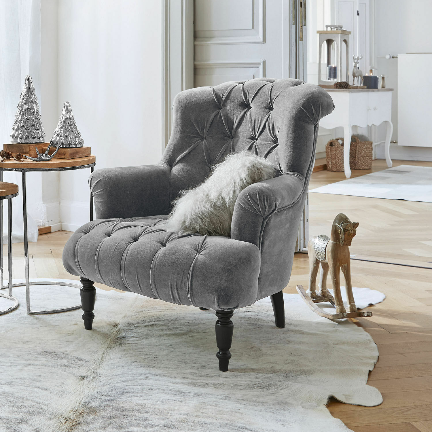 Sillón Parranquet Sillón gris de terciopelo capitoné con patas de madera negra en salón luminoso con decoración elegante