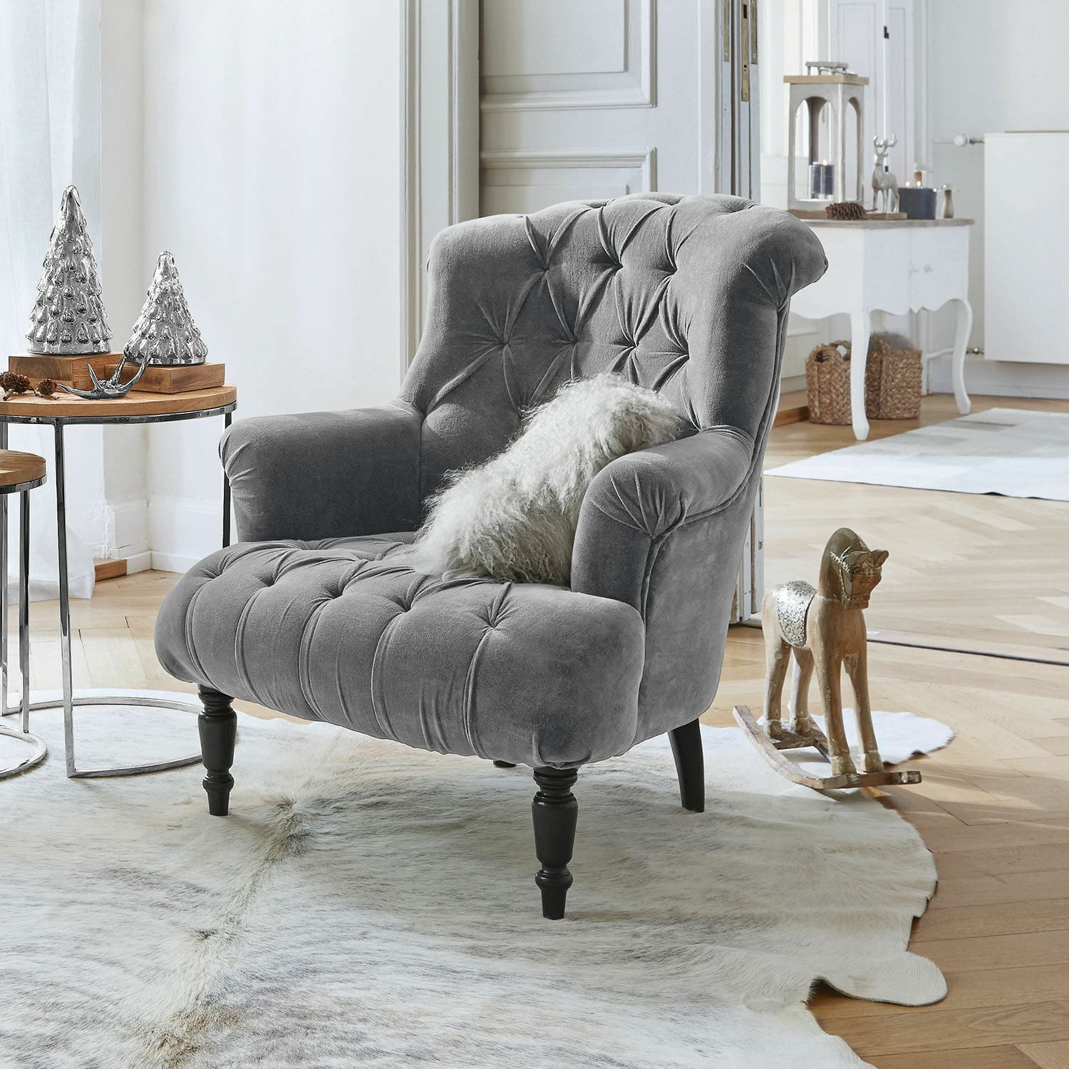 Sillón Parranquet Sillón gris de terciopelo capitoné con patas de madera negra en salón luminoso con decoración elegante
