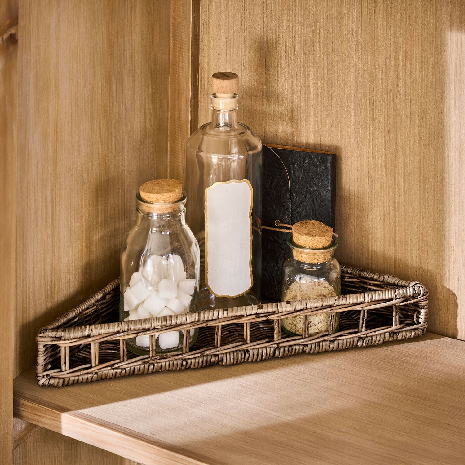Cesta triangular Célunise Cesta triangular de ratán natural con tres botellas de vidrio y un cuaderno en estante de madera