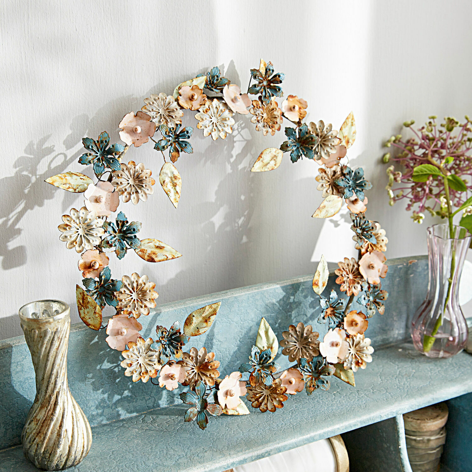 Corona Littleton Corona decorativa de metal en azul, rosa y crema sobre estante para decoración interior