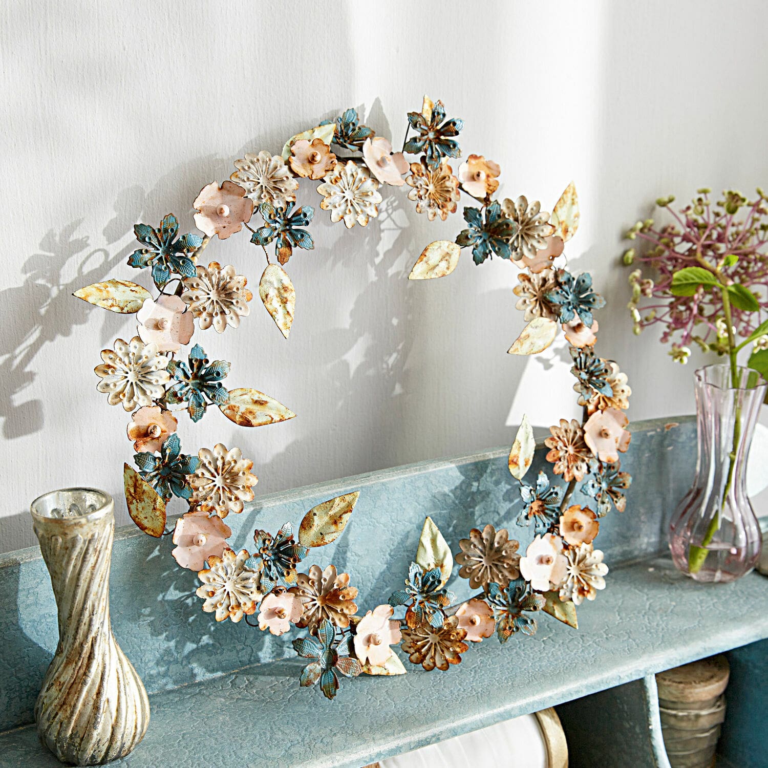 Corona Littleton Corona decorativa de metal en azul, rosa y crema sobre estante para decoración interior
