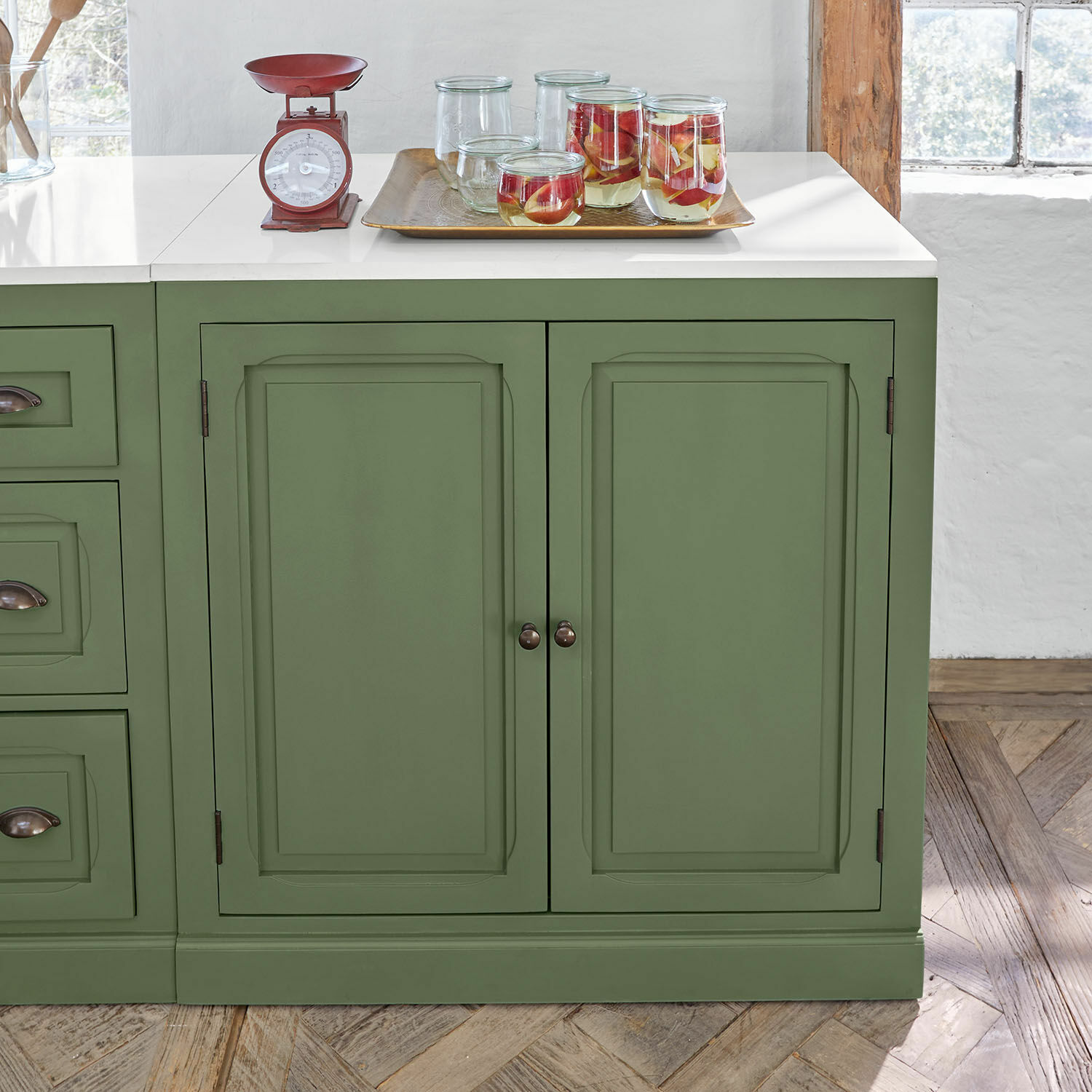 Armario de cocina Lansbury Aparador verde de madera con encimera blanca y balanza de cocina roja de metal encima