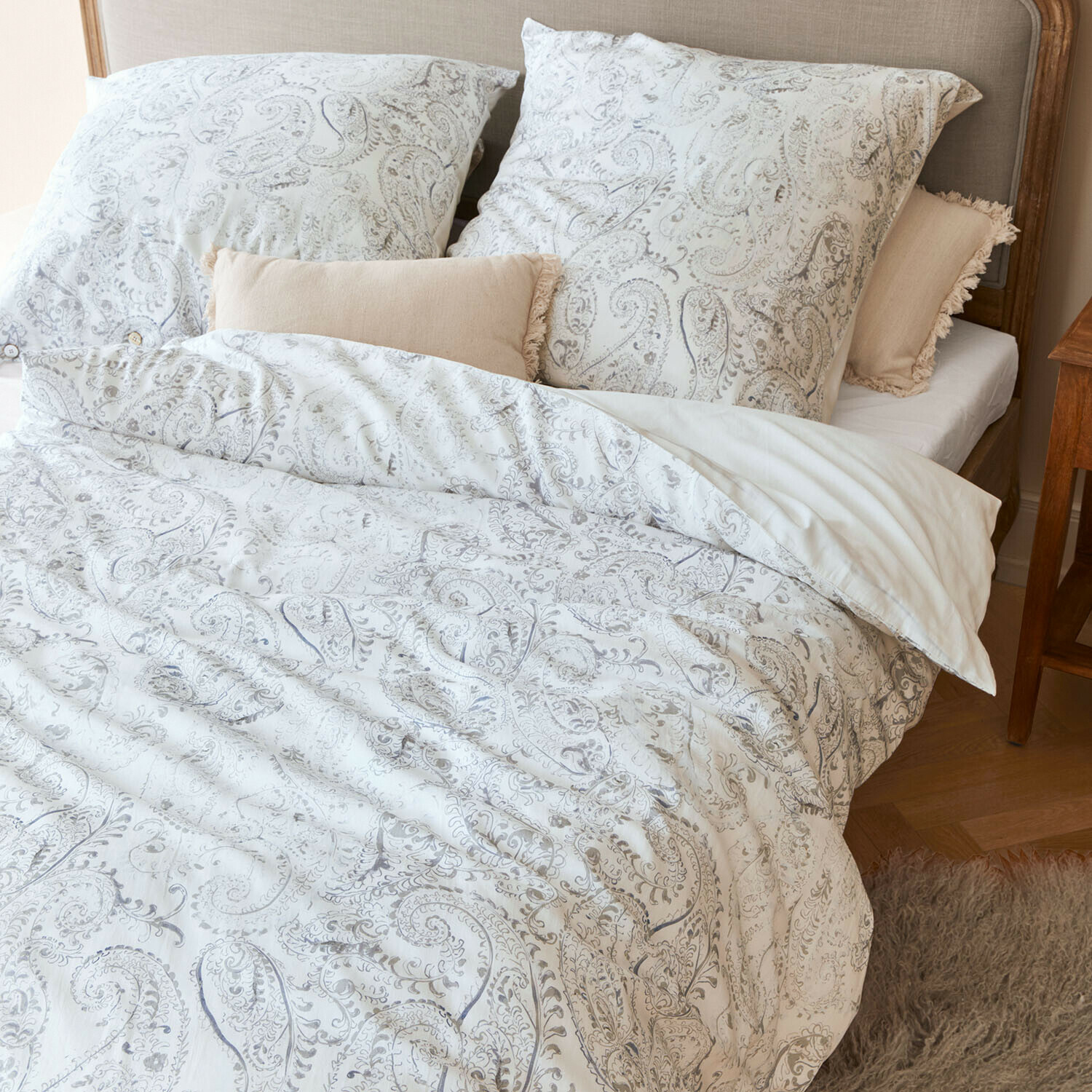 Ropa de cama Caselia Ropa de cama de algodón con diseño paisley claro en cama con cojines decorativos beige