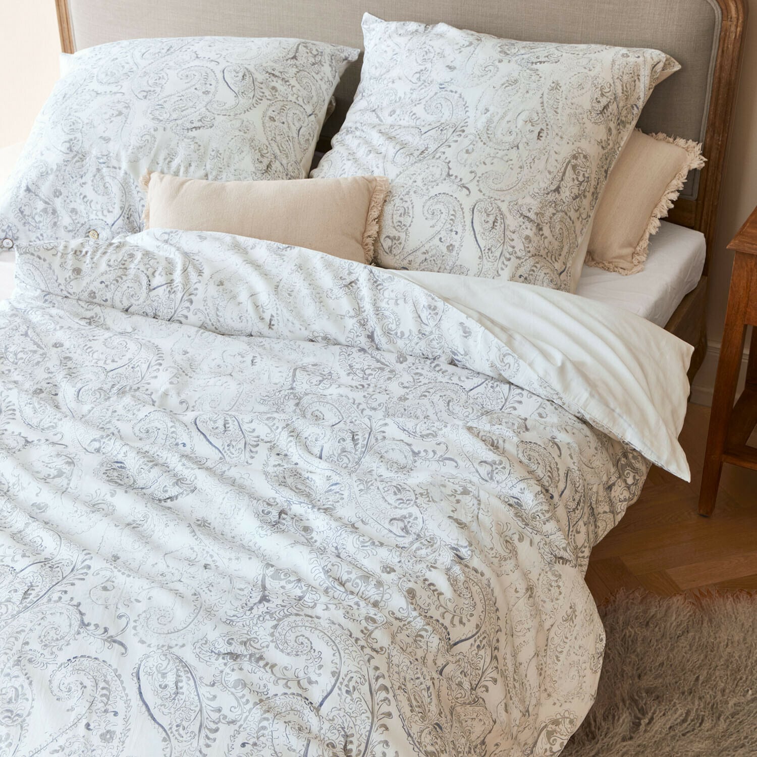 Ropa de cama Caselia Ropa de cama de algodón con diseño paisley claro en cama con cojines decorativos beige