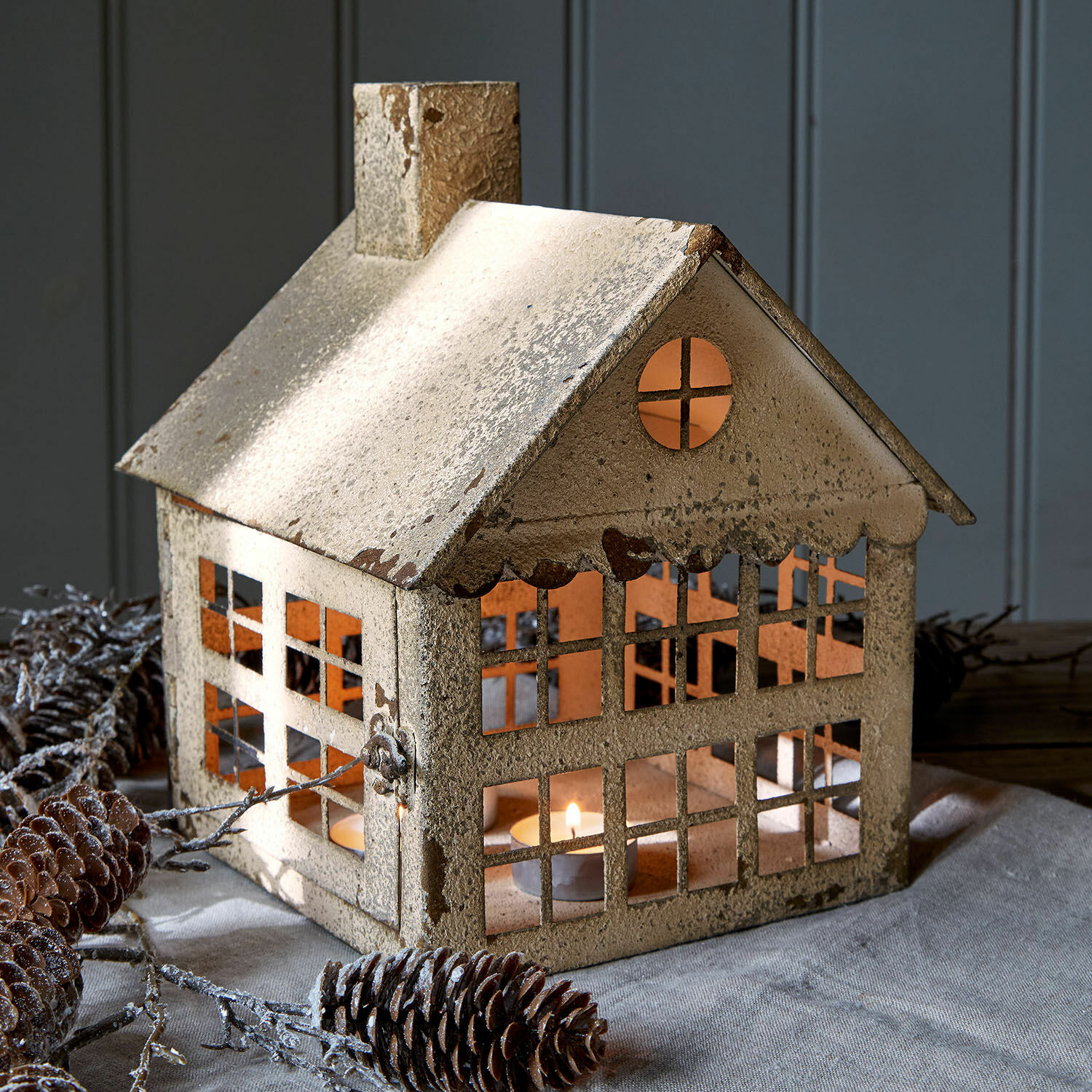 Portavelas Bjornvik Farol de metal beige con forma de casa, espacio para vela y acabado rústico para decoración acogedora
