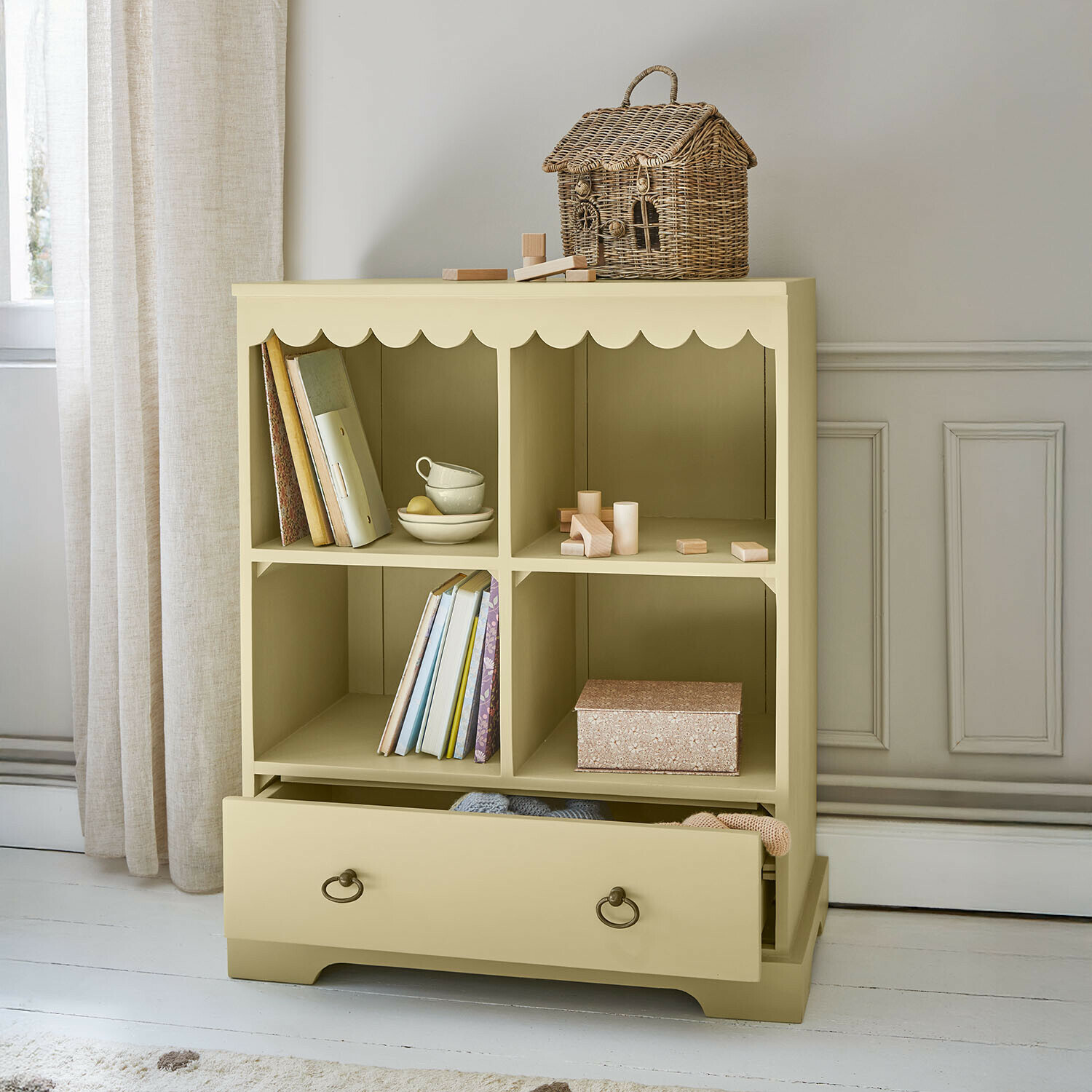 Cómoda de madera beige con cuatro compartimentos y cajón, cesta decorativa de mimbre encima