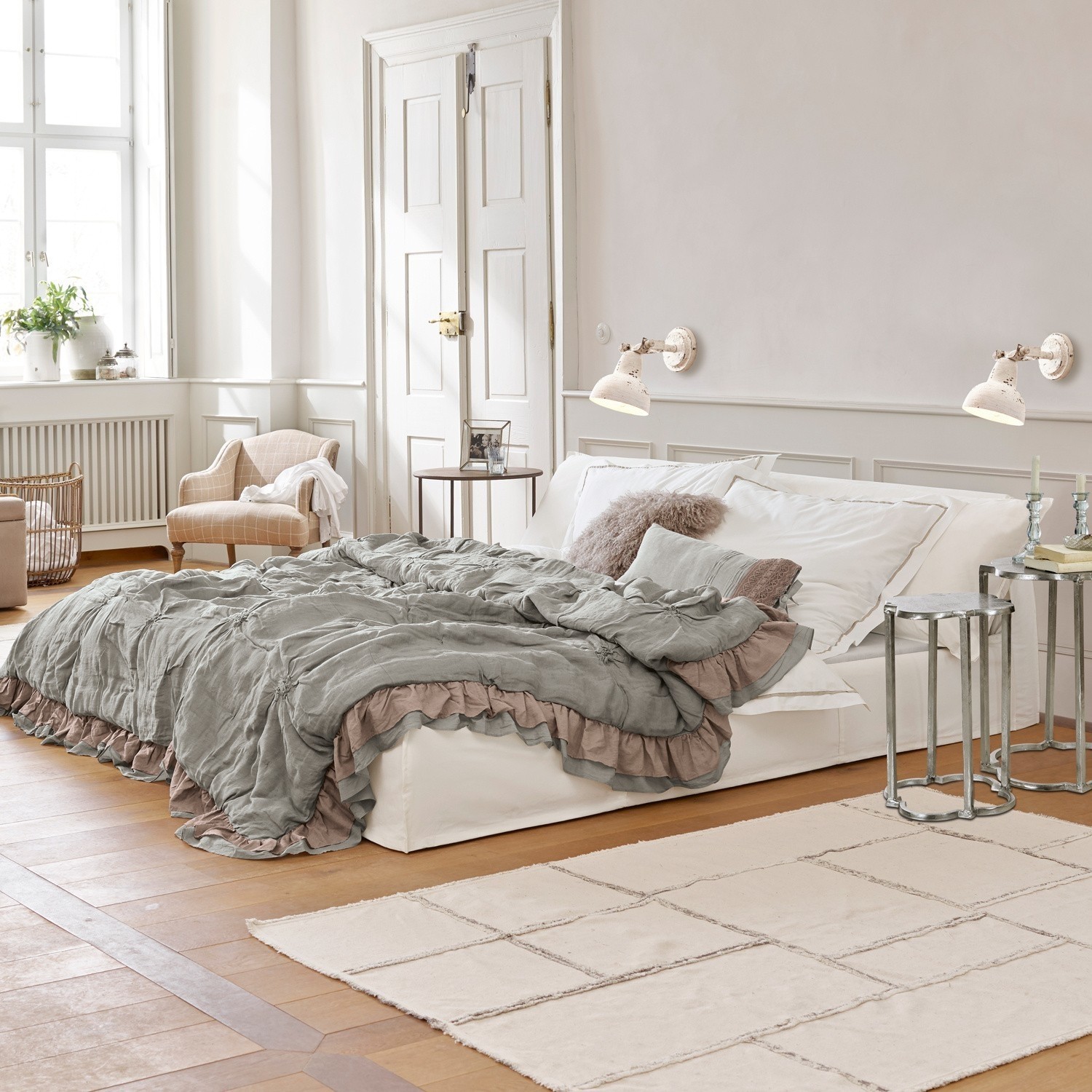 Cama Cottonwood Dormitorio acogedor con cama blanca y colcha gris verdosa con volantes sobre suelo de madera clara