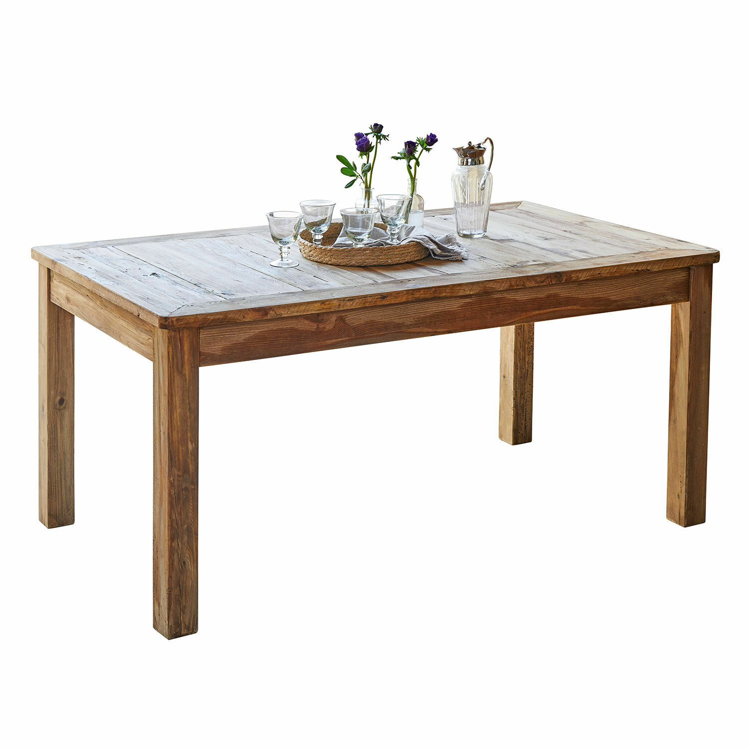 Mesa de comedor de madera natural con decoración de vasos y flores sobre la superficie
