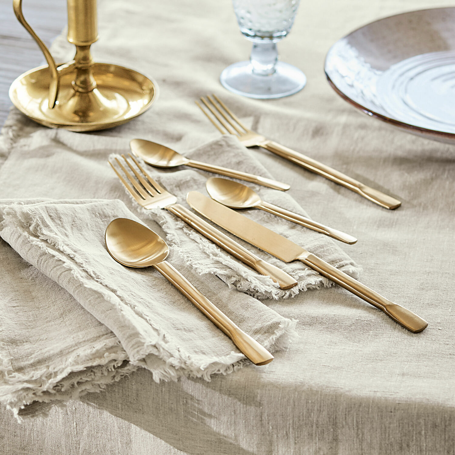 Cubertería Malroy Juego de cubiertos dorados de acero inoxidable sobre mantel de lino para mesa elegante