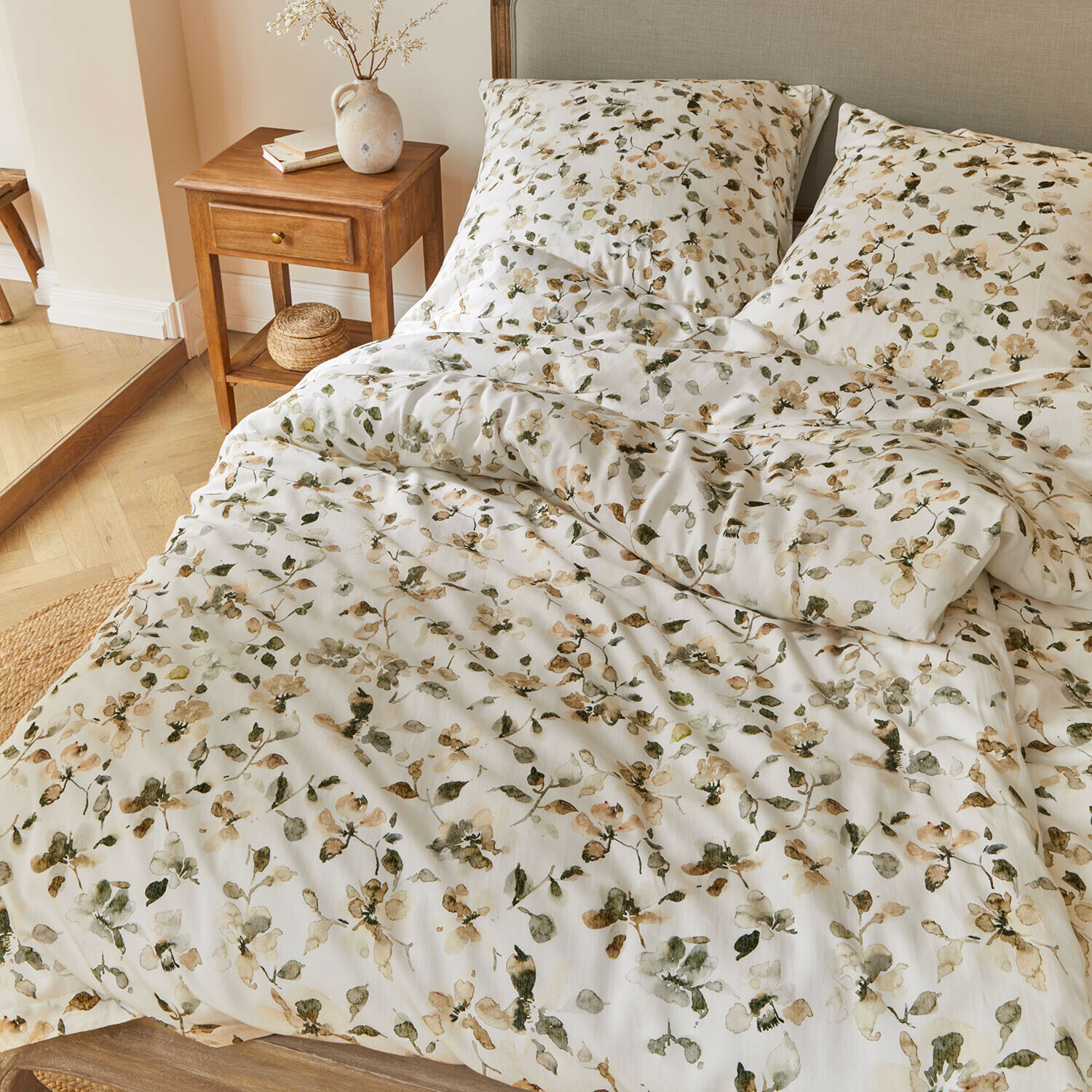 Ropa de cama Lavendrie Ropa de cama de algodón con estampado floral en tonos verdes y beige sobre fondo blanco en dormitorio