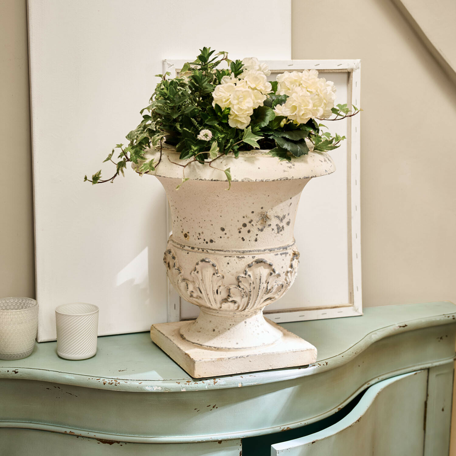 Ánfora Lorianza Jarrón de cerámica blanca con decoración floral sobre cómoda verde envejecida estilo vintage