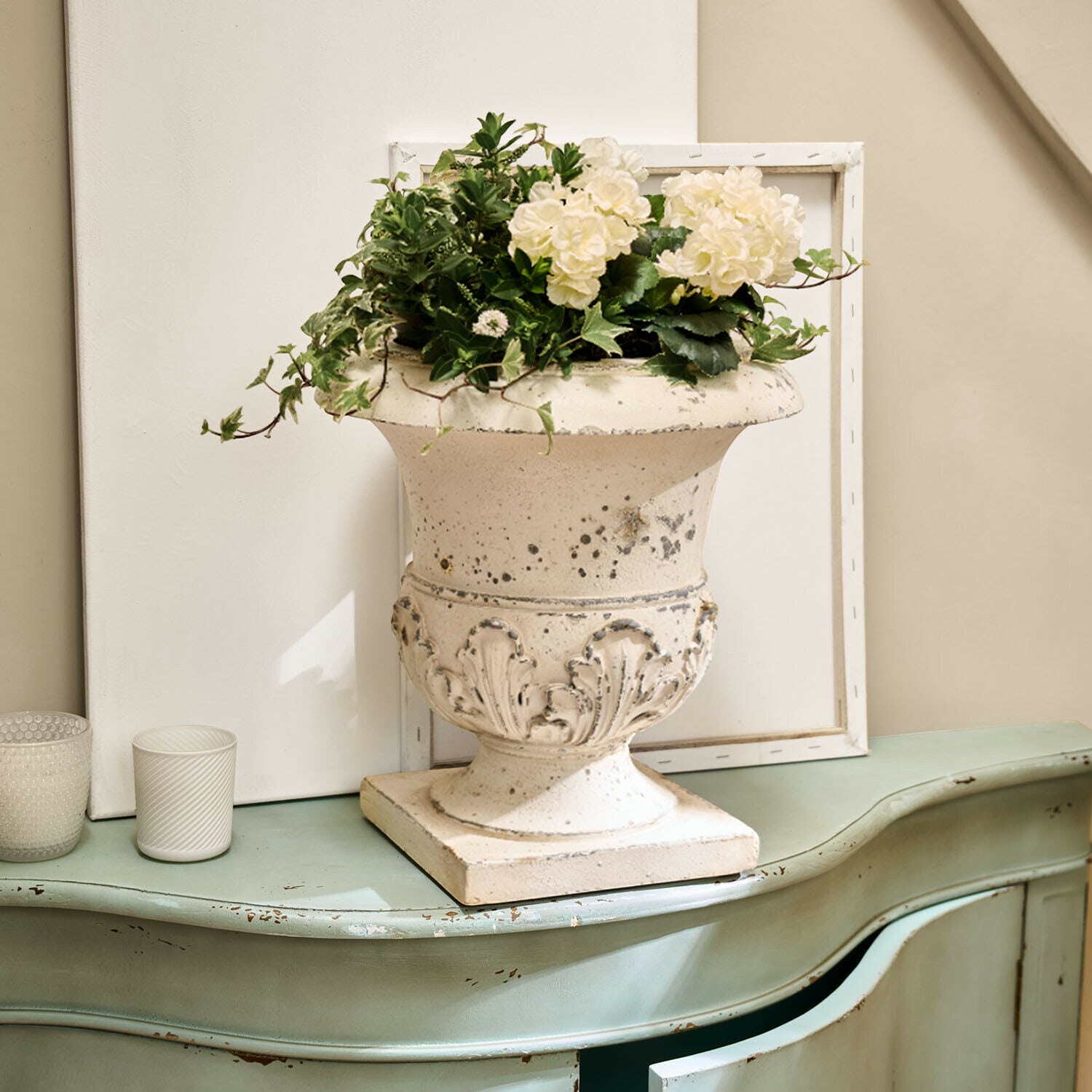Ánfora Lorianza Jarrón de cerámica blanca con decoración floral sobre cómoda verde envejecida estilo vintage