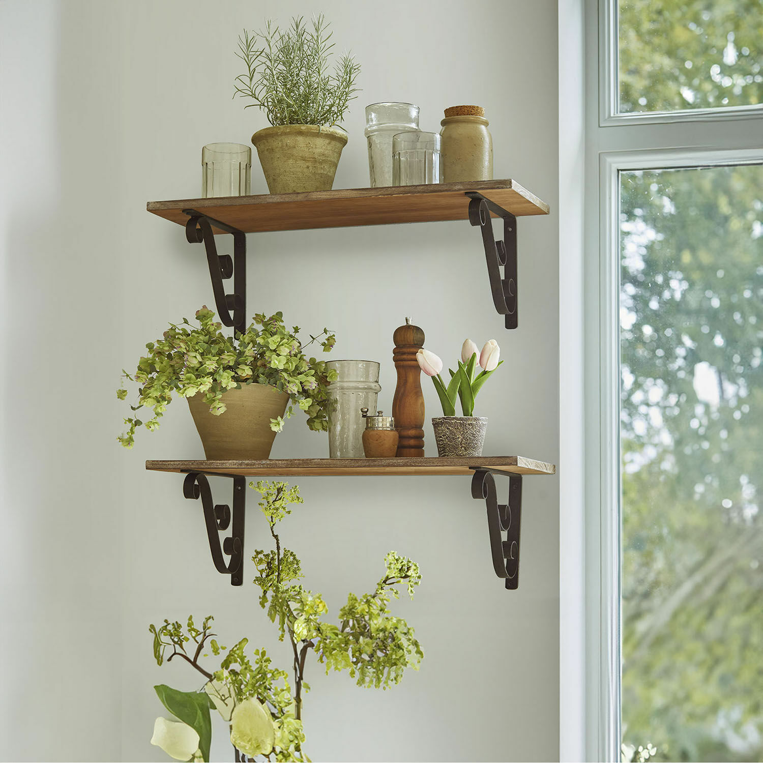 Set de 2 estantes de pared Dravile Estantes de madera con soportes metálicos, decorados con macetas y vasos en un interior luminoso
