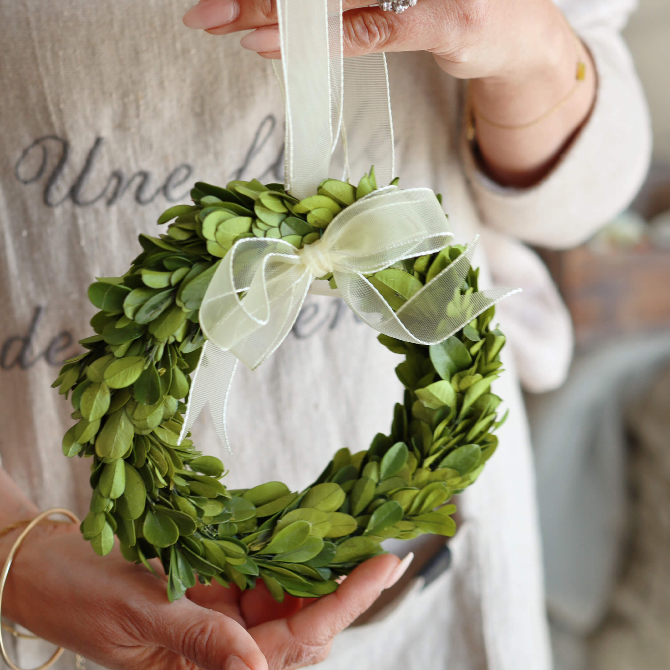 Pequeña corona verde de hojas con lazo blanco, decoración para el hogar o puerta