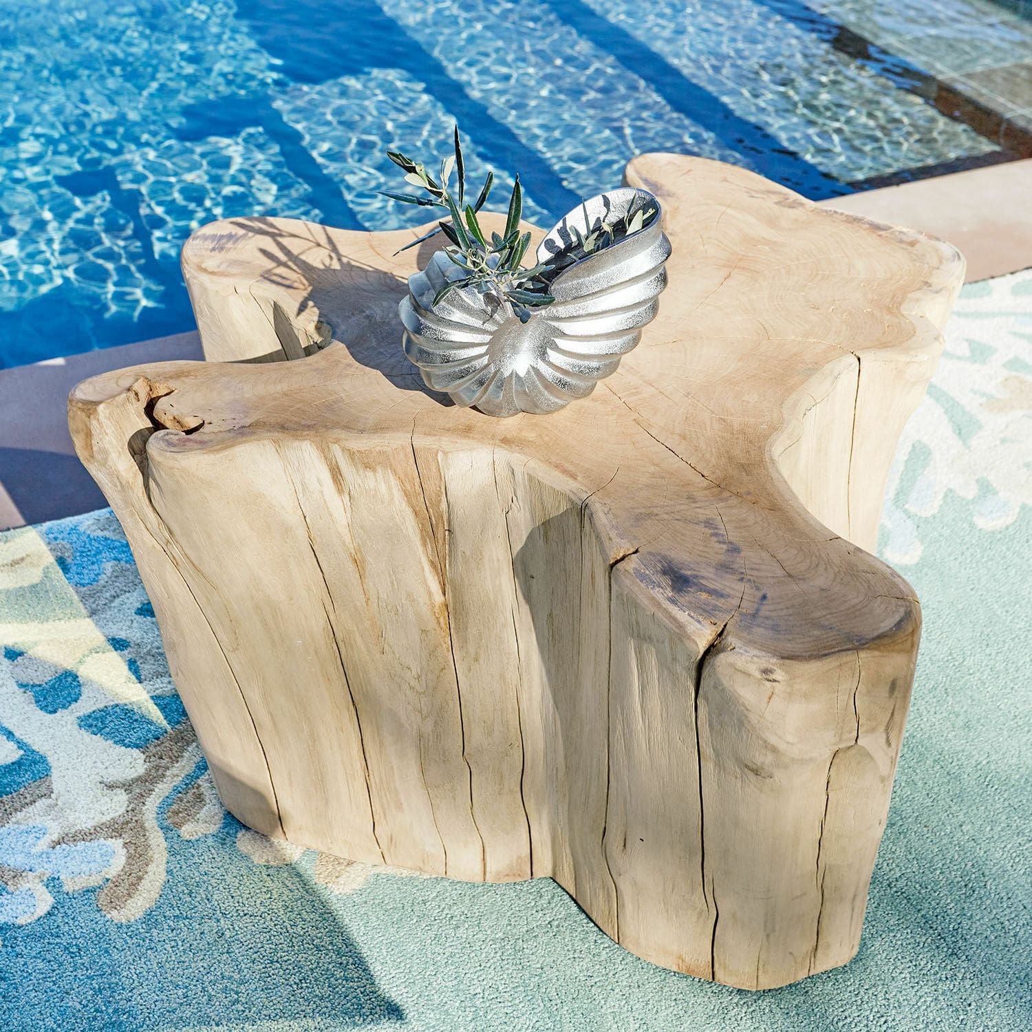 Mesa de centro Dorlancourt Mesa de madera maciza con forma natural junto a piscina sobre alfombra, adorno metálico