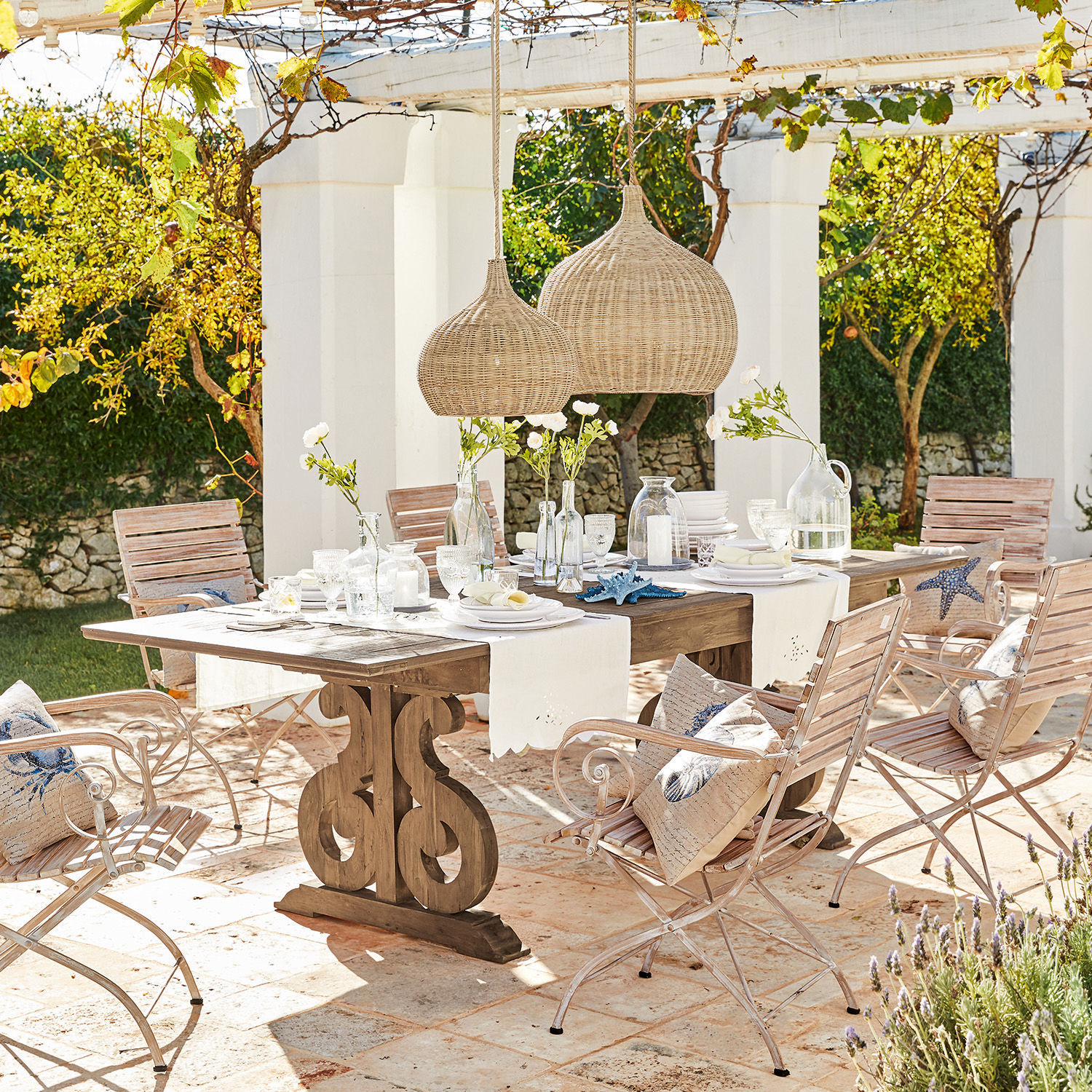 Mesa Concarneau Conjunto de muebles de jardín con mesa de madera y sillas metálicas claras en terraza soleada