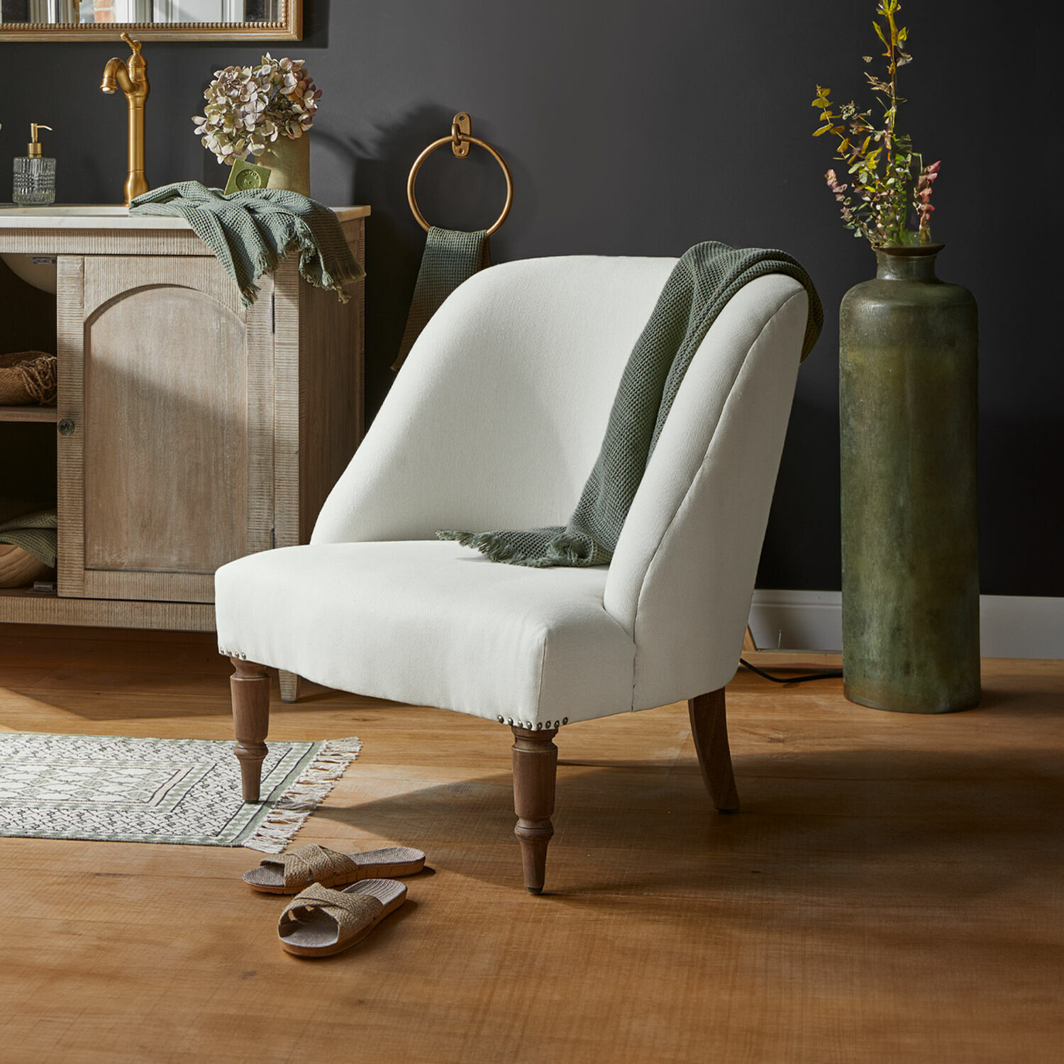 Sillón Maplewood Sillón tapizado blanco con patas de madera y manta verde en interior moderno