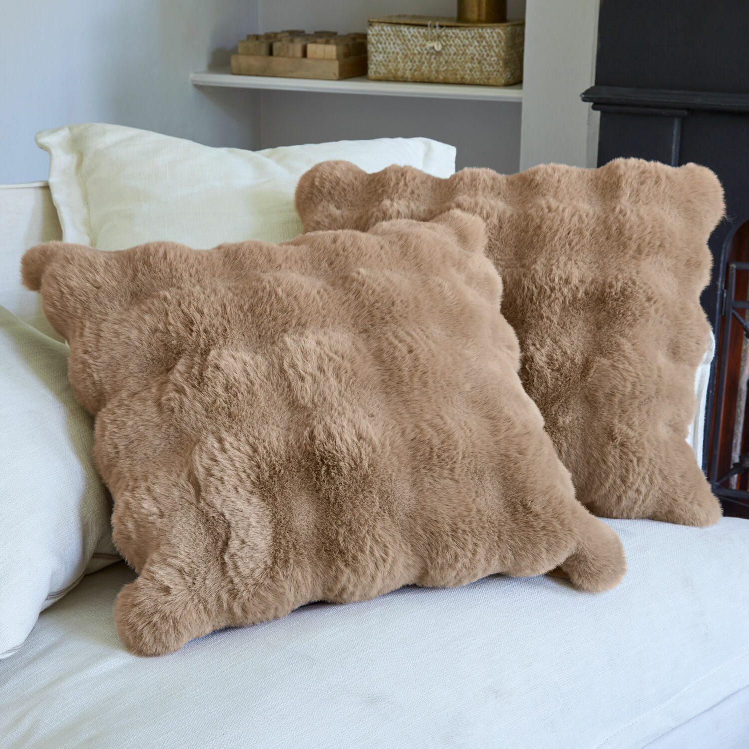 Set de 2 fundas de cojín Zalina Cojines beige de piel sintética sobre sofá claro, decoración acogedora y cómoda