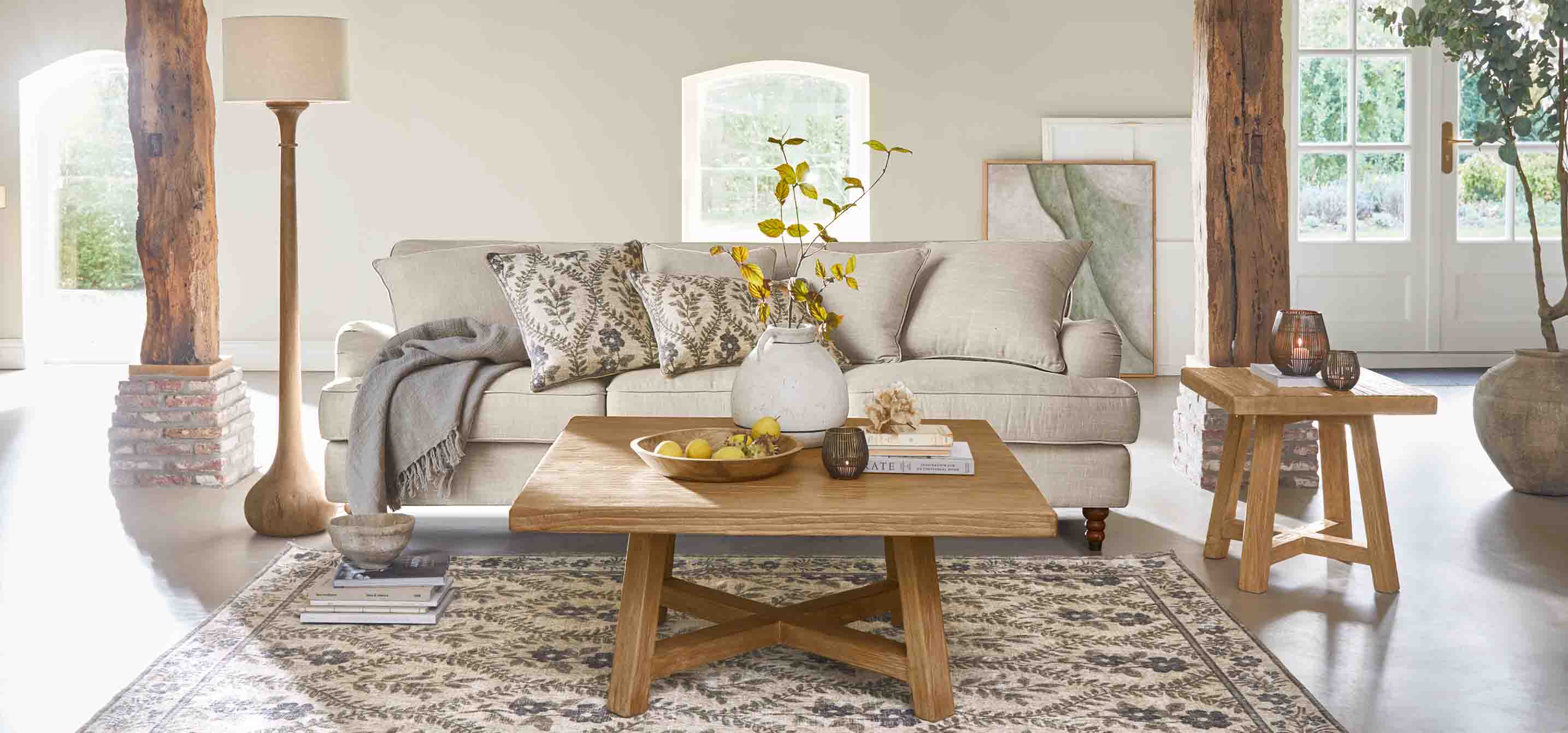 Salón acogedor con sofá beige, mesa de madera y lámpara de pie en tonos naturales