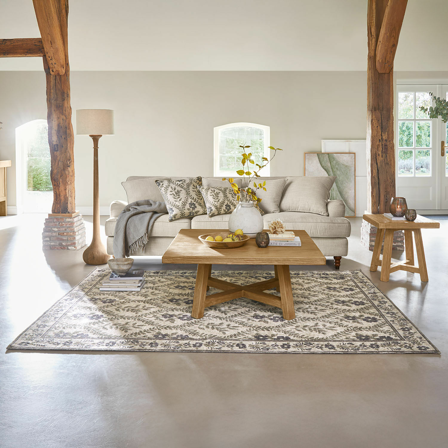Alfombra Vellouris Sala acogedora con sofá beige, mesa de centro de madera y alfombra con diseño vegetal
