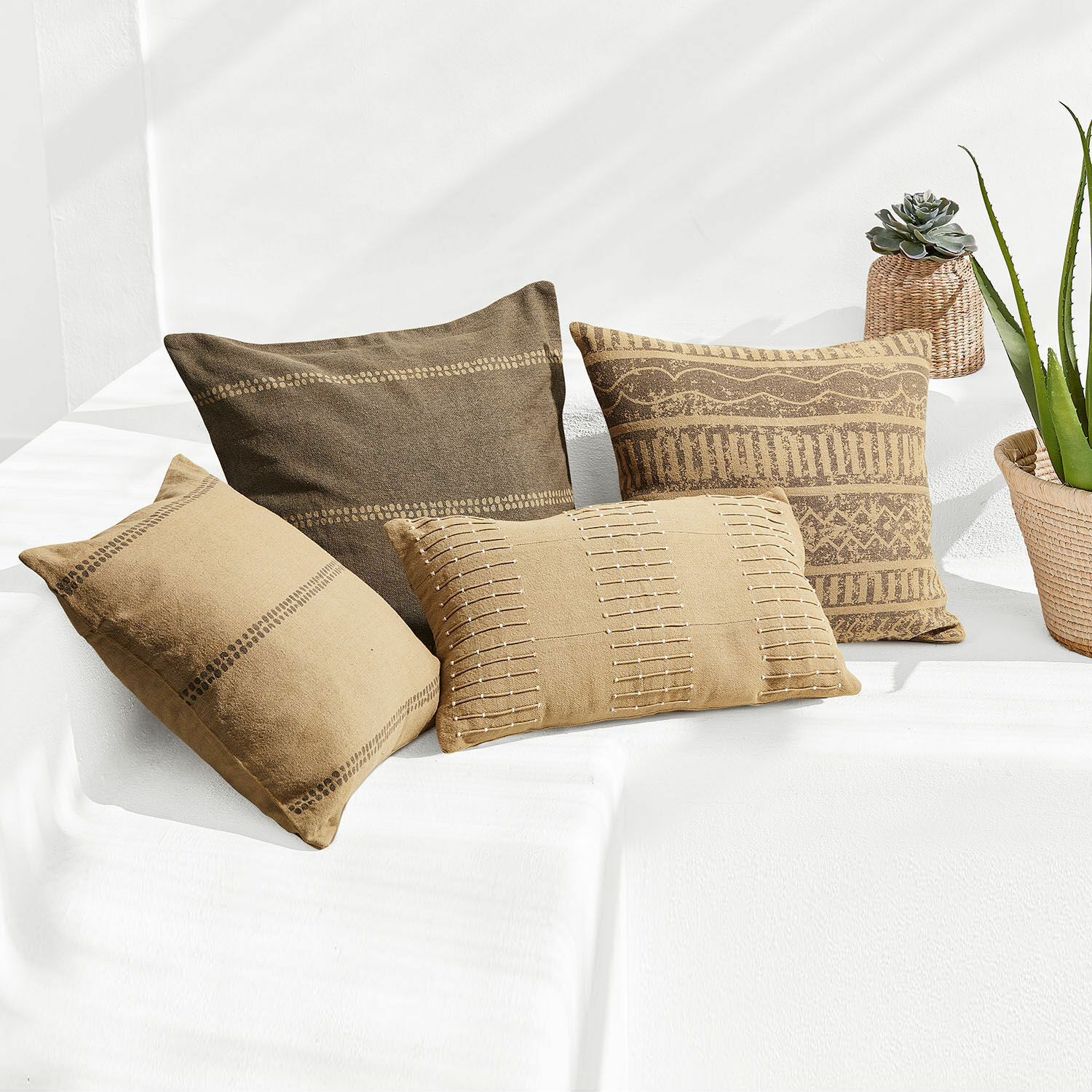 Set de 4 fundas de cojín Patti Conjunto de cuatro cojines decorativos de algodón marrón con patrones geométricos para sala