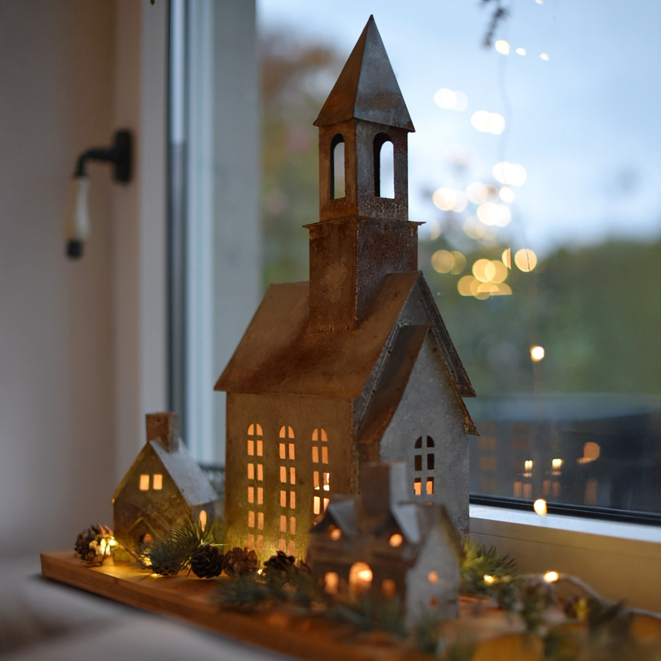 Conjunto decorativo de casas y iglesia de metal con iluminación LED sobre base de madera
