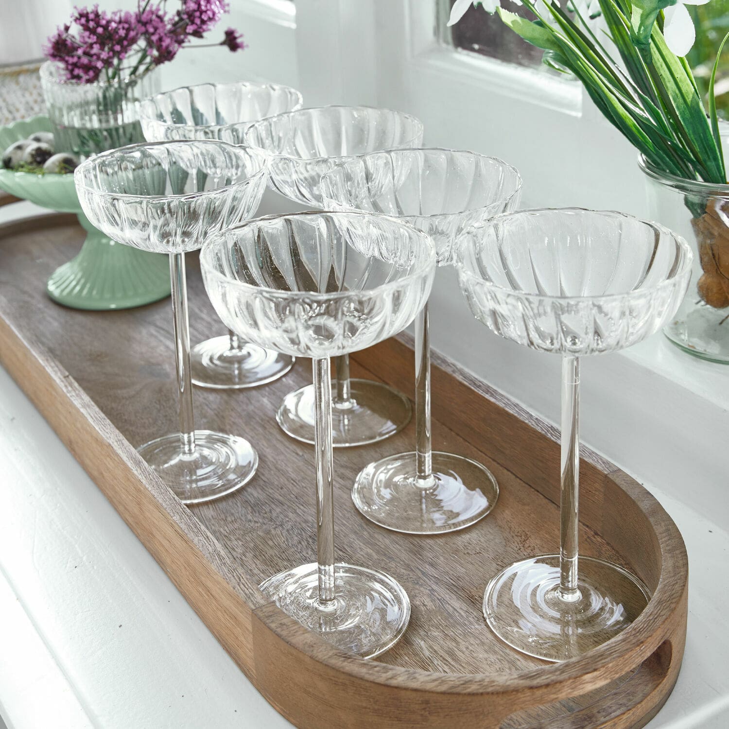 Set de 6 vasos Bavella Conjunto de seis copas de cóctel transparentes de vidrio estriado sobre bandeja de madera
