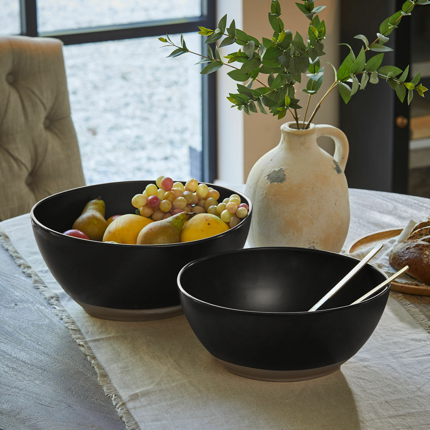 Set de 2 ensaladeras Biarré Dos cuencos de cerámica negra con verduras verdes sobre mesa de madera clara