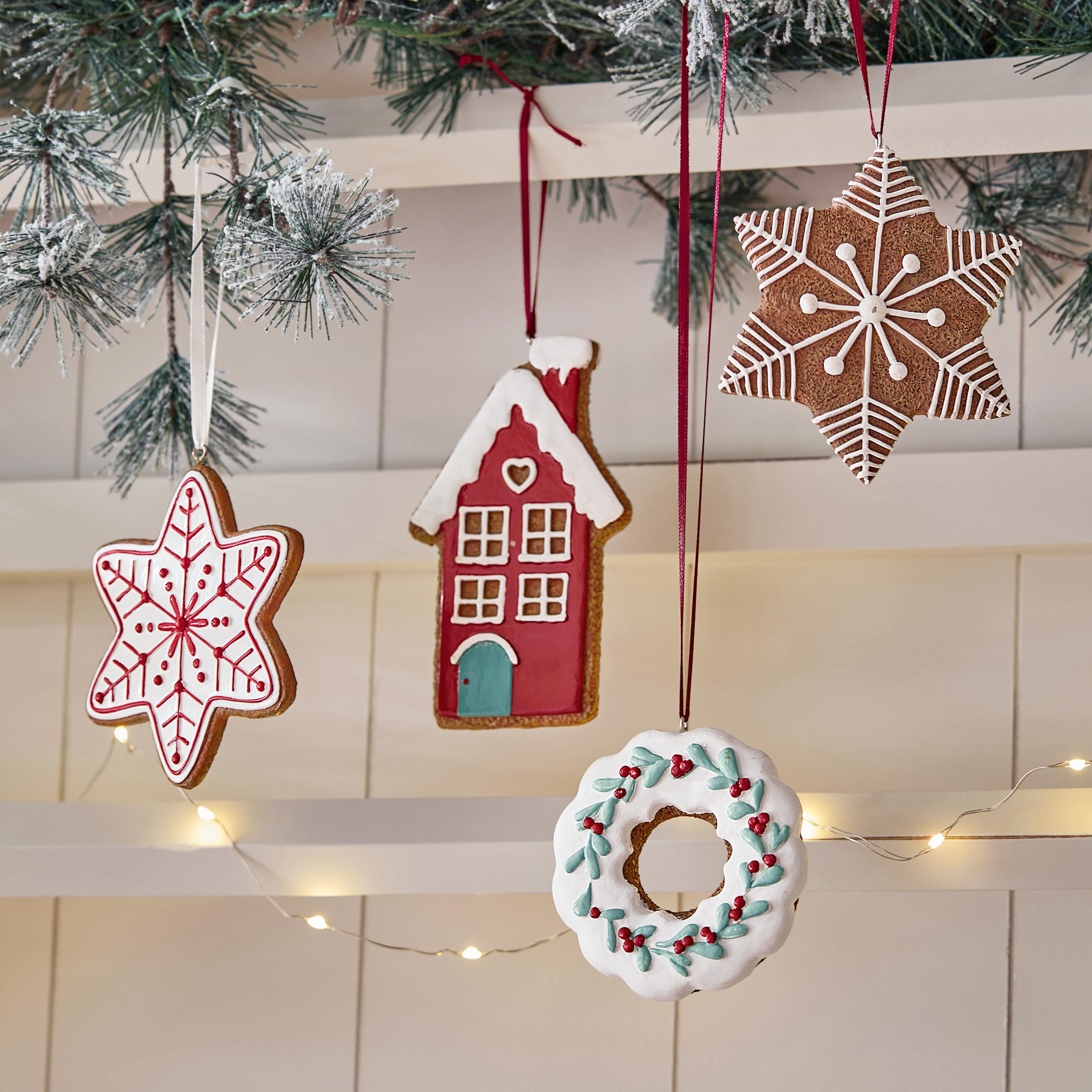 Adornos navideños de jengibre en forma de estrella, casa y corona con glaseado de colores colgados