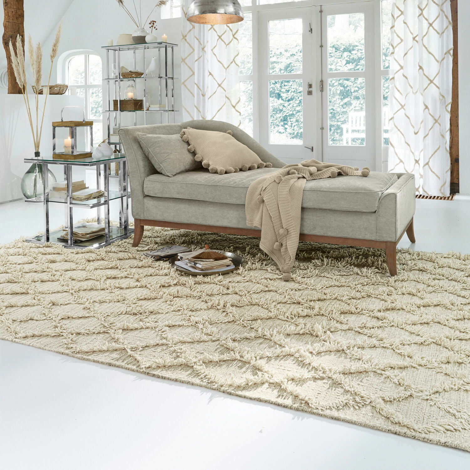 Chaise longue tapizada gris con patas de madera sobre alfombra beige en sala luminosa