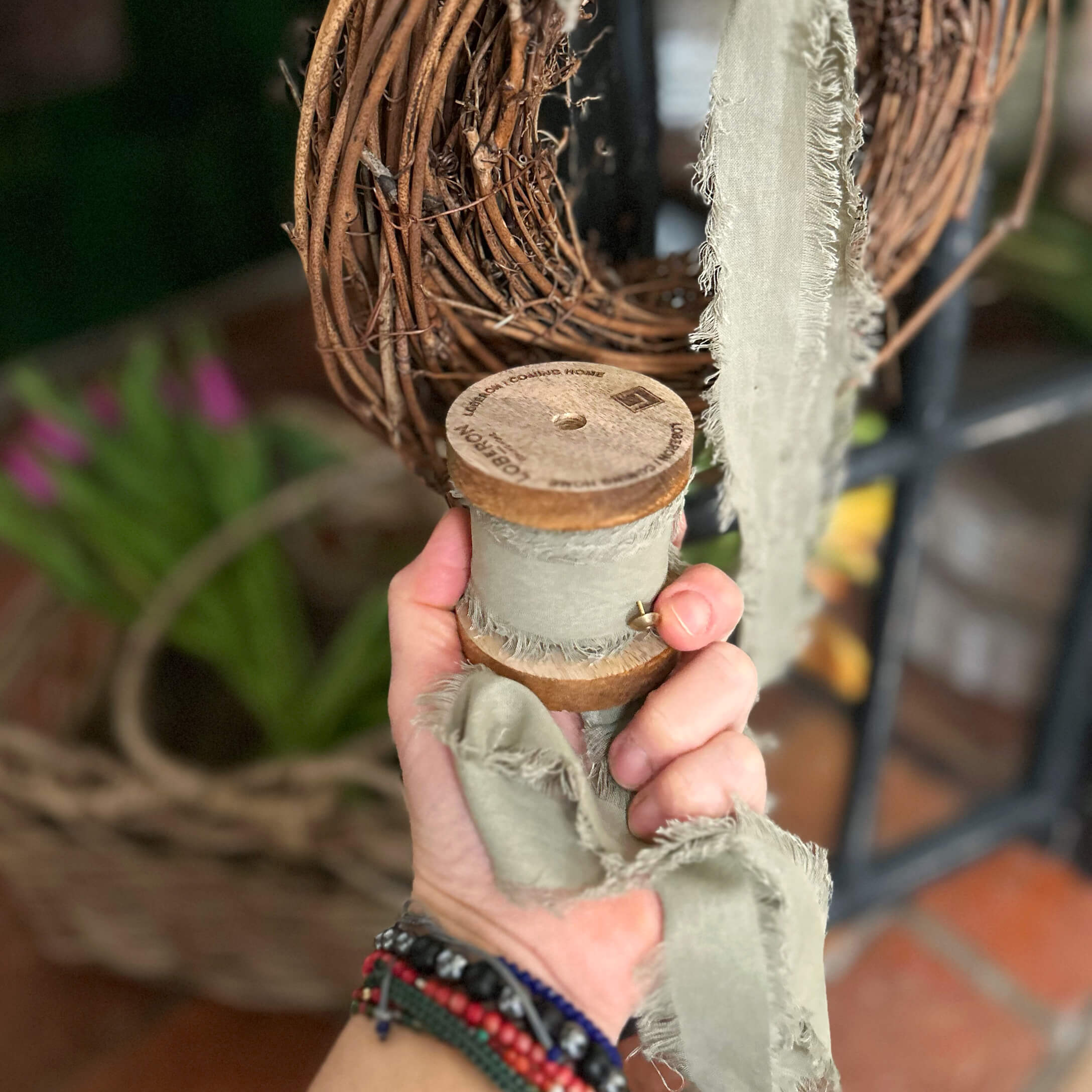 Cinta gris de algodón con bordes deshilachados en carrete de madera para decoración y manualidades