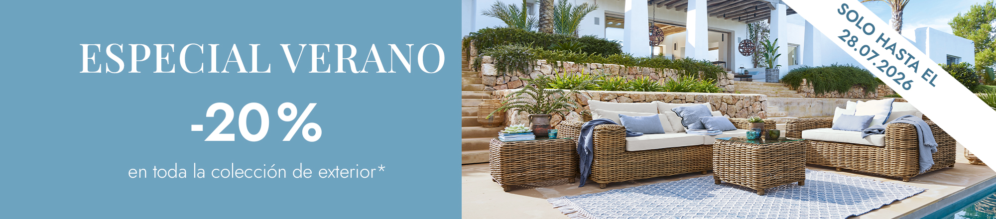 Conjunto de muebles de exterior de ratán natural con cojines claros y alfombra azul junto a la piscina