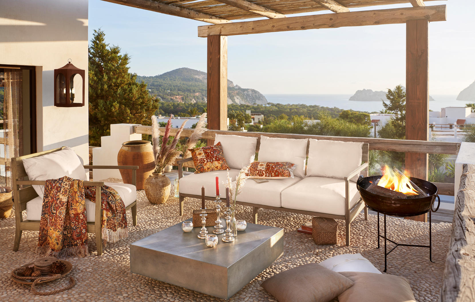 Terraza acogedora con cojines beige y detalles orientales con vistas al mar y montañas