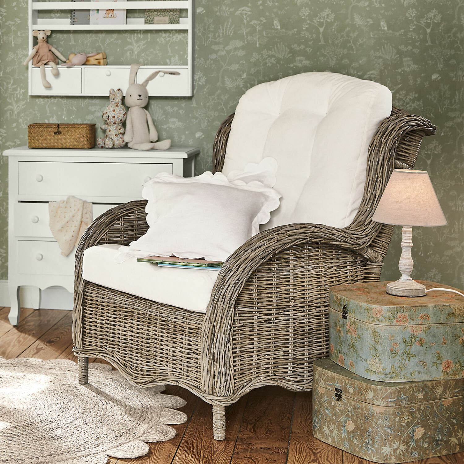 Sillón Hailee Sillón de mimbre con cojín blanco en interior acogedor con lámpara y cómoda decorativa