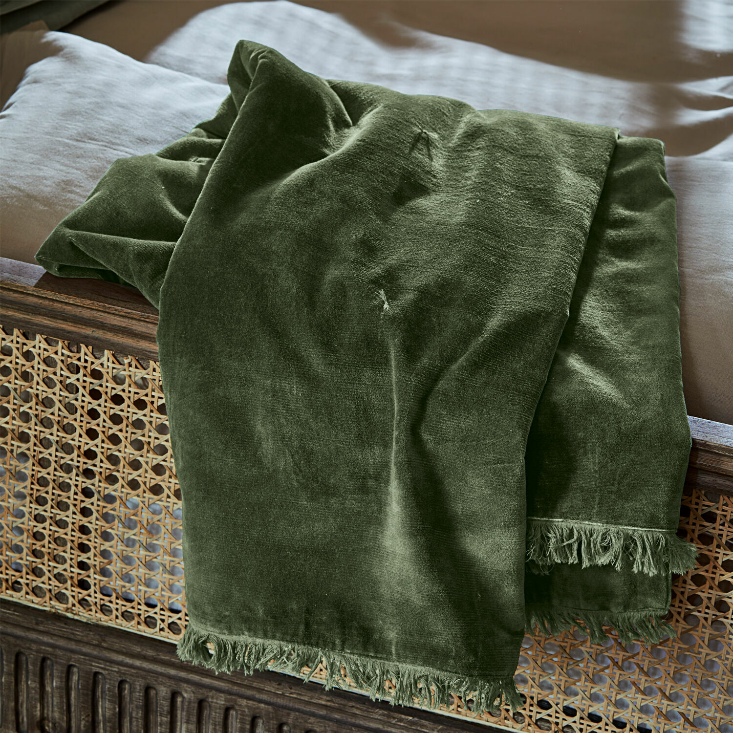 Plaid Maelis Manta verde de terciopelo con flecos sobre cama de madera, textil suave y decorativo para dormitorio
