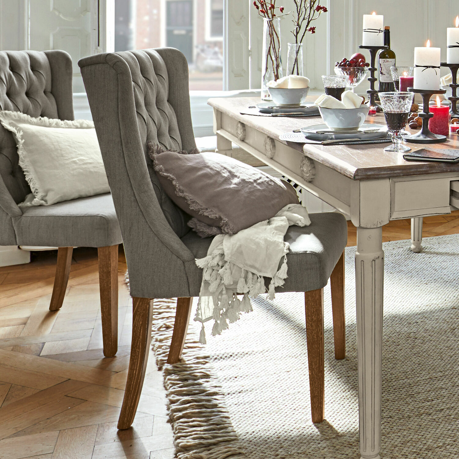 Silla Sudbury Silla tapizada gris con patas de madera junto a mesa vintage clara, decoraciones sobre la mesa