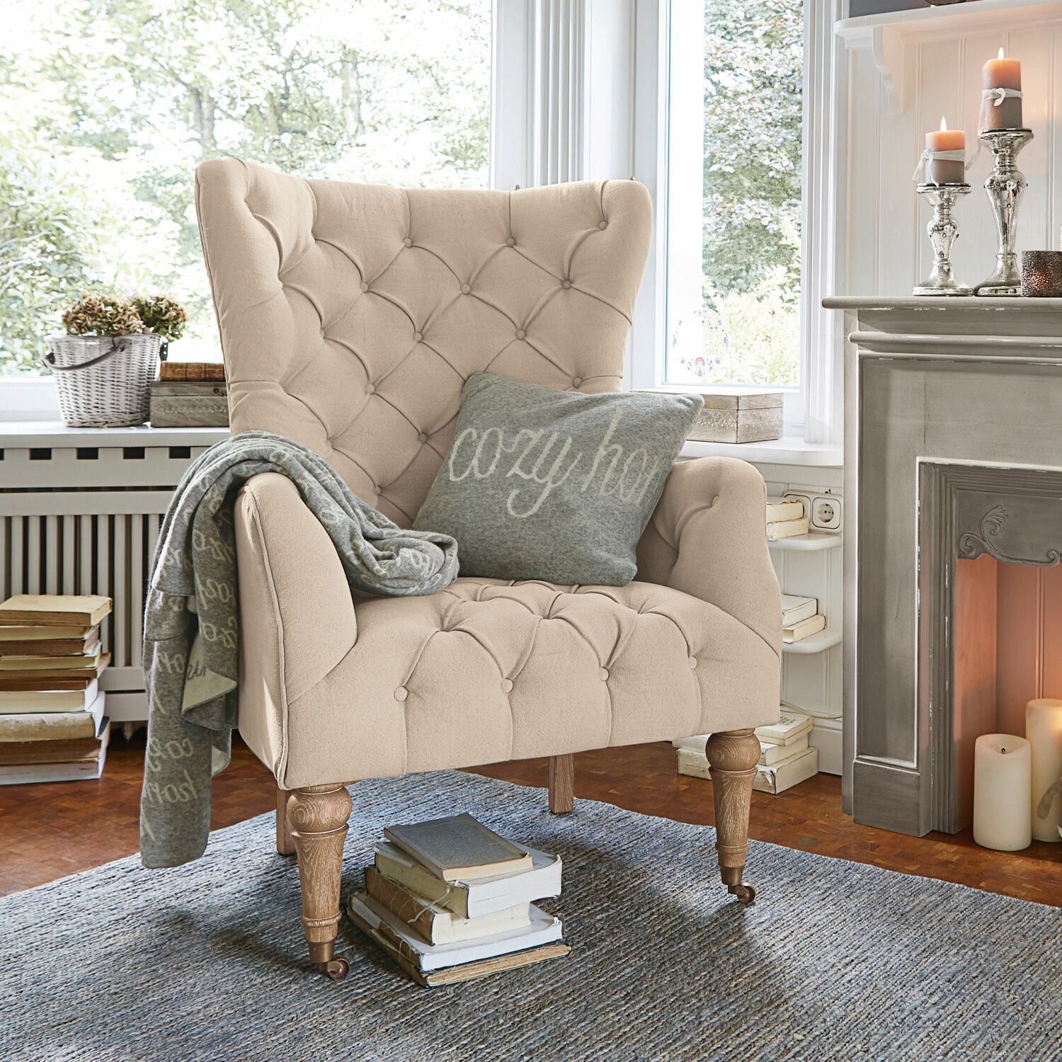 Sillón Migré Sillón beige acolchado con patas de madera en sala acogedora junto a chimenea encendida