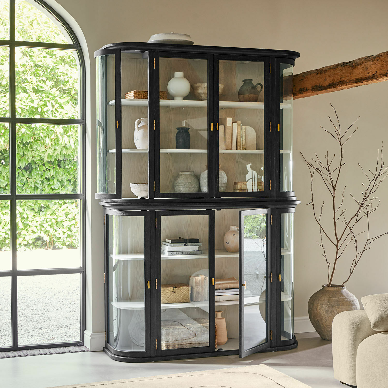 Vitrina negra de madera con puertas de cristal y estantes, mueble moderno para salón luminoso