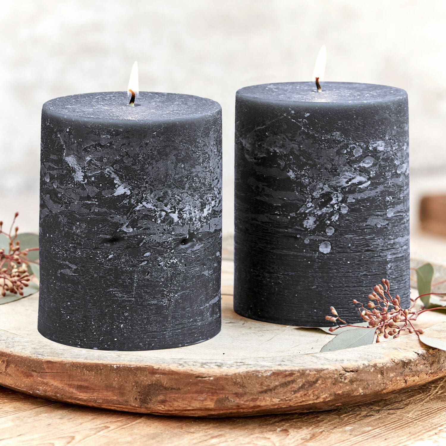 Set de 2 velas Oviedo Dos velas negras de cera texturizada sobre una bandeja decorativa de madera