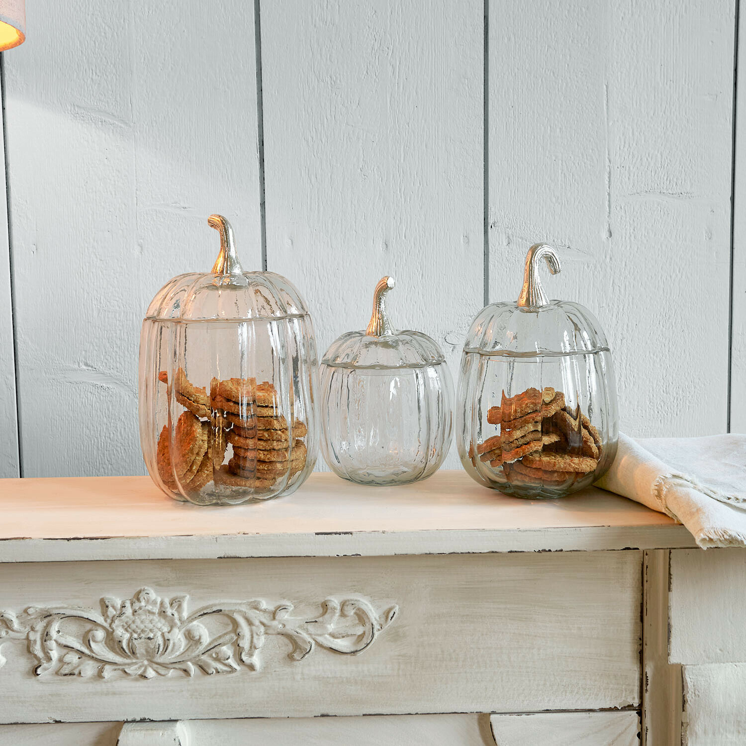 Set de 3 tarros de cristal Alérisse Conjunto de tres frascos de vidrio transparente con forma de calabaza con galletas sobre una mesa de madera