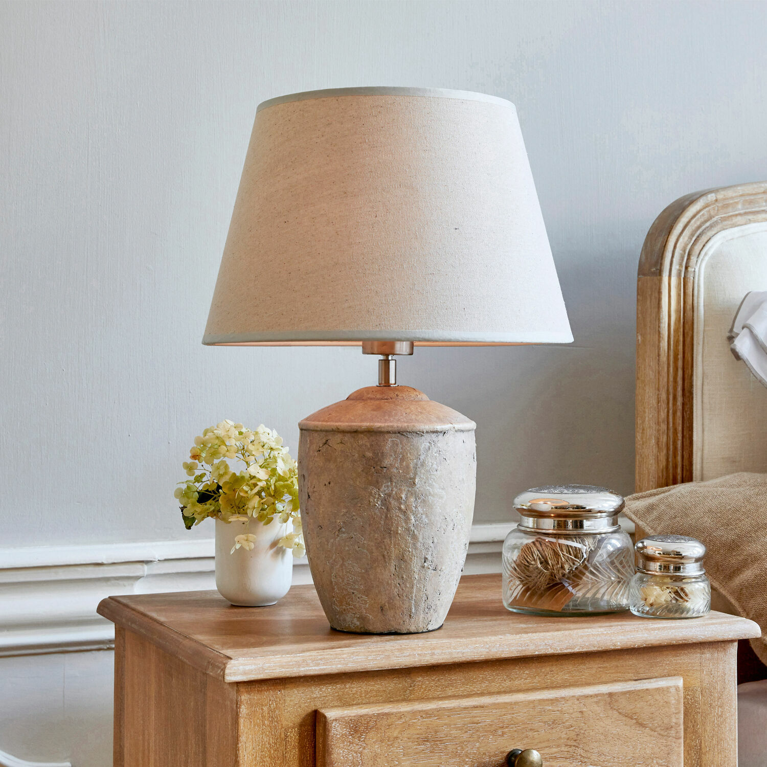 Lámpara de mesa Verfaille Lámpara de mesa con pantalla beige y base de cerámica sobre mesita de noche de madera