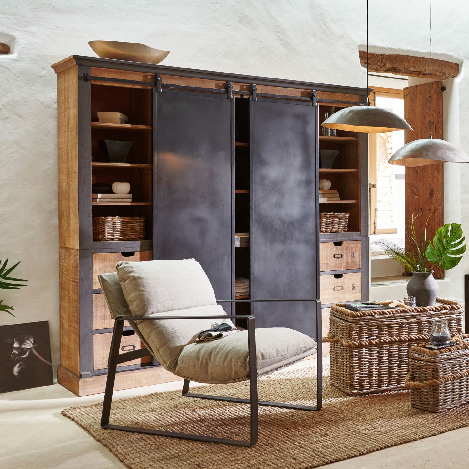 Armario Vulmont Sillón moderno con estructura metálica y cojín beige en sala natural con cestas de mimbre