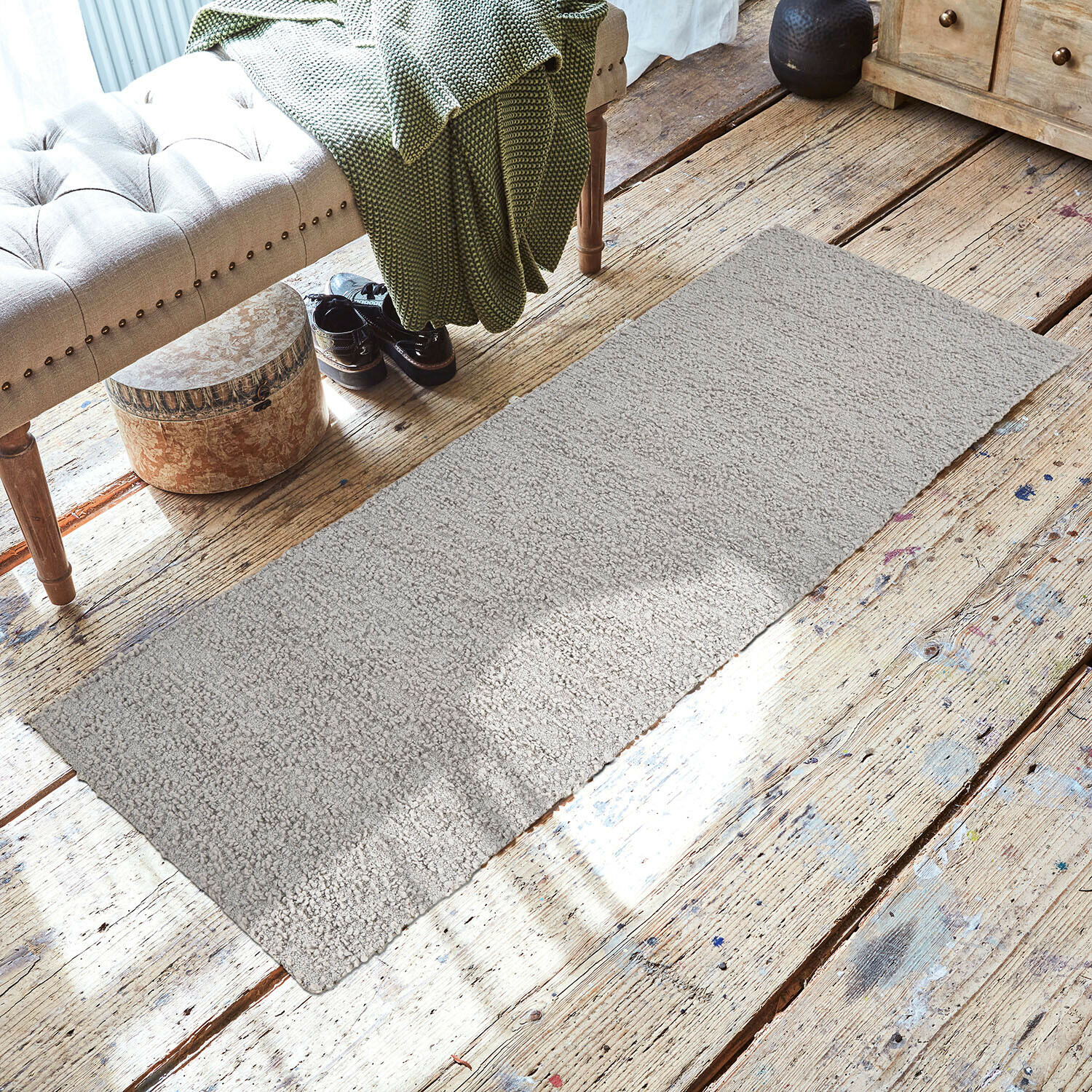 Alfombra Kaleema Alfombra gris de material suave sobre suelo de madera en interior acogedor con banco y manta verde