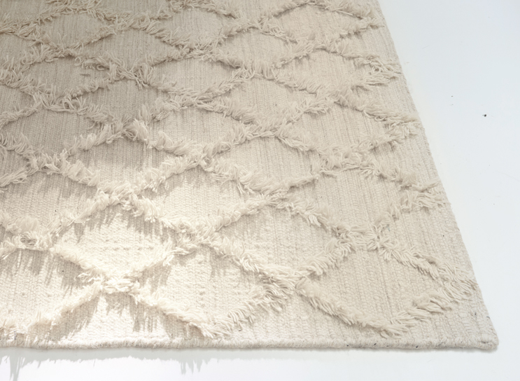 Alfombra beige con patrón de rombos y flecos, decoración de interiores estilo bohemio