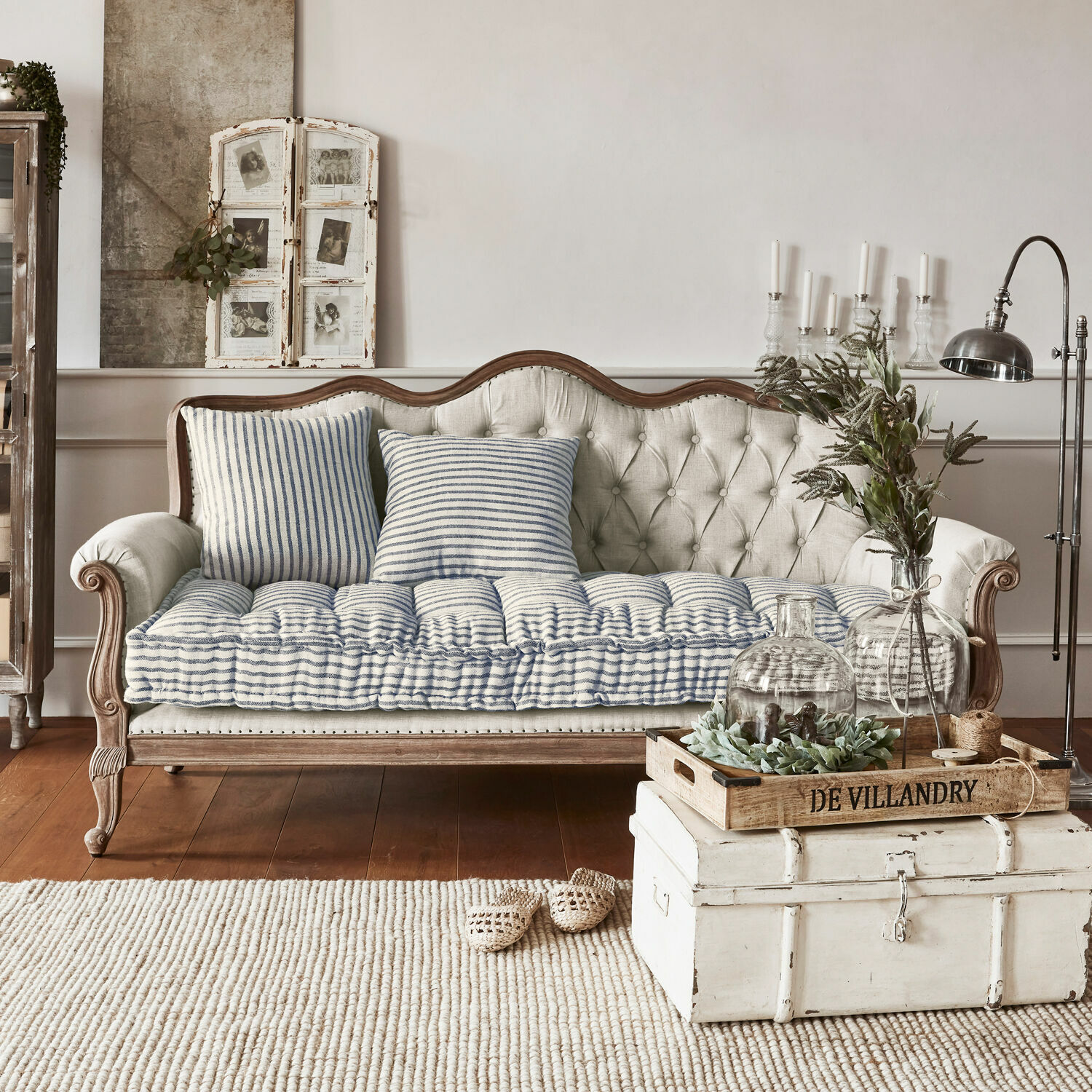 Sofa Malabon Sofá beige acolchado con marco de madera y cojines a rayas azul y blanco en estilo vintage