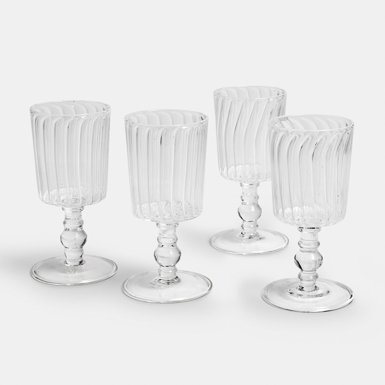 Conjunto de cuatro copas transparentes de vidrio estriado con pie para bebidas