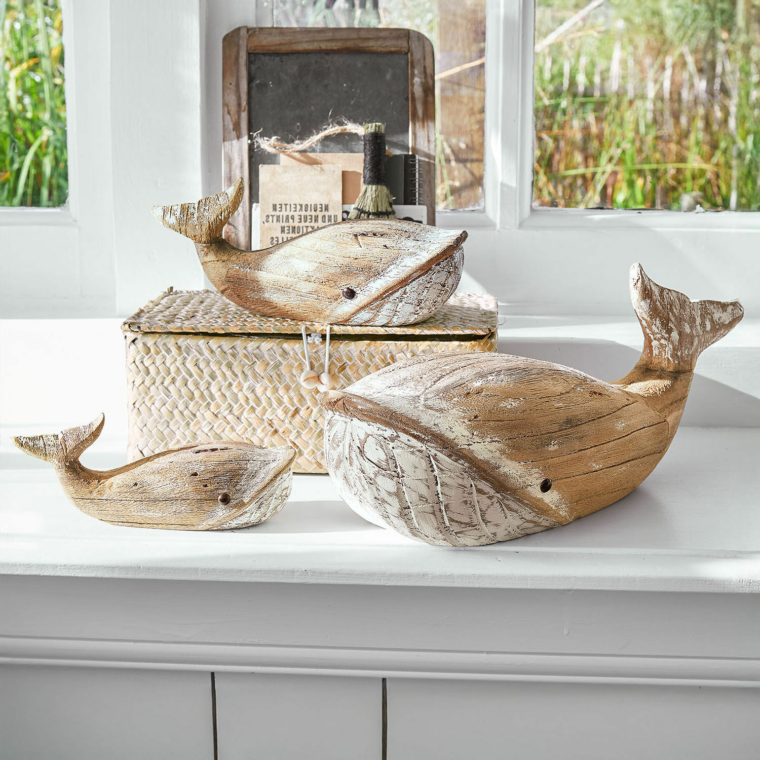 Set de 3 ballenas decorativas Breezie Conjunto de tres ballenas decorativas de madera en color natural con detalles blancos sobre el alféizar